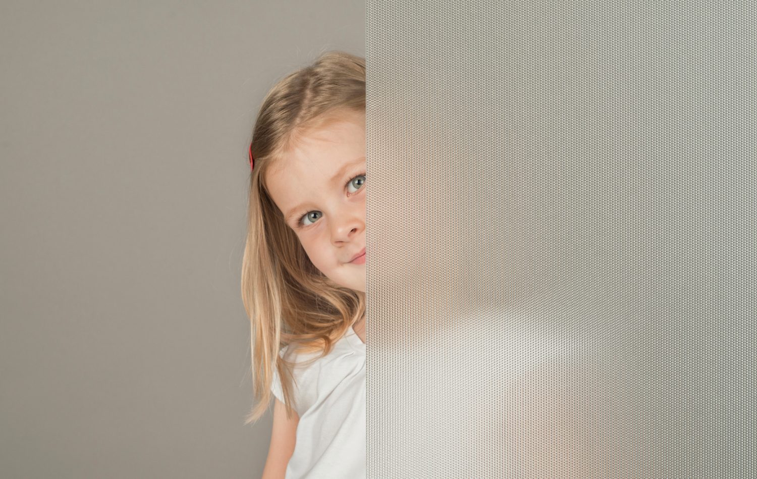 Bambina dietro un vetro strutturato Internorm, a illustrare la qualità del vetro